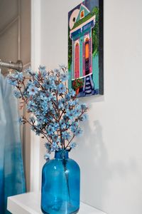 Cheerful blue floral decor & vibrant artwork add a festive, local flair.