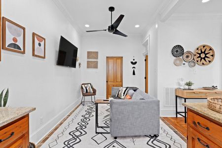 Cozy living room w/ warm tones & a peek into the fully equipped kitchen.