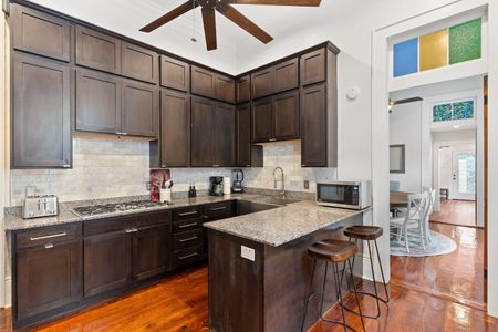 Fully stocked kitchen w/ granite counters, dark cabinetry & bar seating for casual bites.