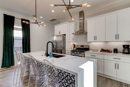 Clean white kitchen w/ gas stove, stainless fridge & generous counter space.