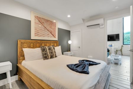 Natural wood bed frame & cozy bedding w/ easy access to the living space.