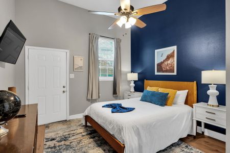Serene bedroom w/ bold navy walls & a plush bed dressed in blue & gold.