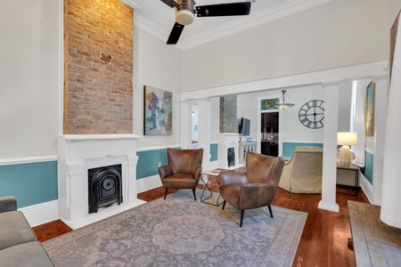 Inviting sitting area w/ a fireplace, leather chairs & teal accents.