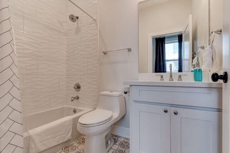 Well-lit bathroom w/ a classic tub & vanity, fresh & functional.