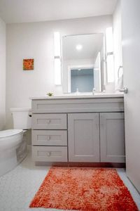 Tidy half bath w/ sink & toilet — conveniently appointed for guests.