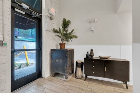 Stylish entryway w/ a dark wood cabinet, potted plant & curated décor.