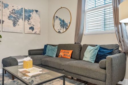 Comfortable living room sofa w/ teal throw pillows — perfect for lounging.