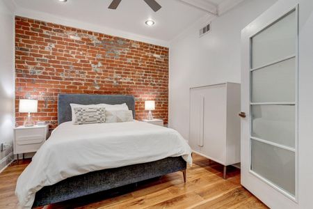 Cozy first bedroom w/ a queen bed & soft, relaxed lighting.