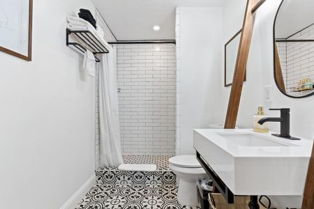 Bright bathroom w/ a soaking tub & natural light filtering through a shaded window.