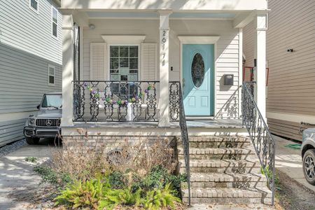 Classic New Orleans façade w/ ironwork details & a charming teal front door.