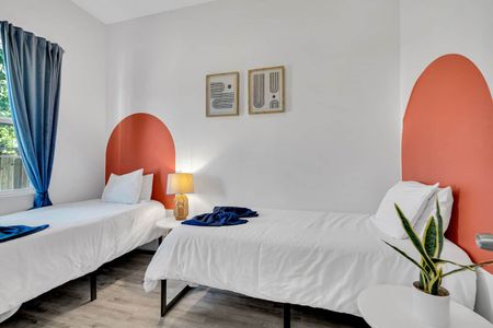 Twin bedroom w/ coral headboard, matching bedding, & a cheerful, personality-filled vibe.