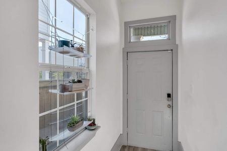 Soft gray bedroom w/ natural light & a calm, welcoming atmosphere.