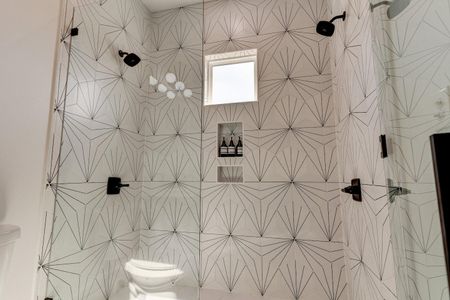 Showstopping bath w/ double shower heads & bold, fabulous tilework.
