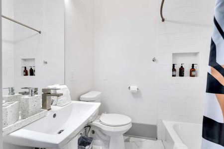 Clean, bright bathroom w/ white fixtures, sink & toilet — simple & refreshing.