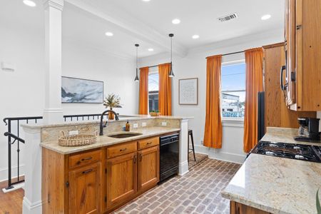Fully stocked kitchen w/ warm wood cabinets, black appliances & plenty of counter space.