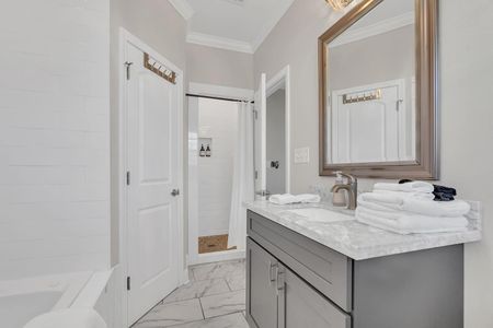Fresh primary bathroom w/ marble countertop, sink & a clean, modern finish.