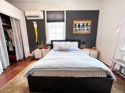 Main bedroom w/ a generous bed & vibrant wall art to set the mood.