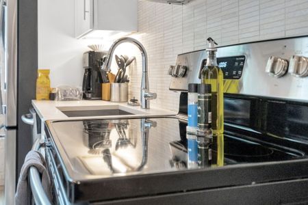 Well-stocked stove area w/ utensils, spices & cookware within easy reach.