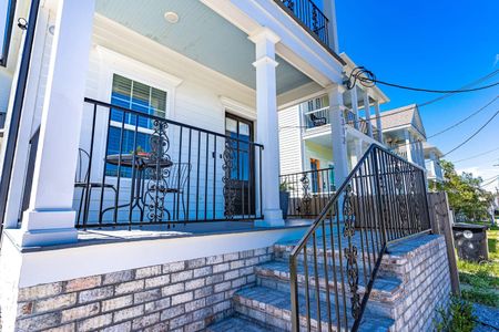Charming front patio w/ classic ironwork — a welcoming entry to come home to.