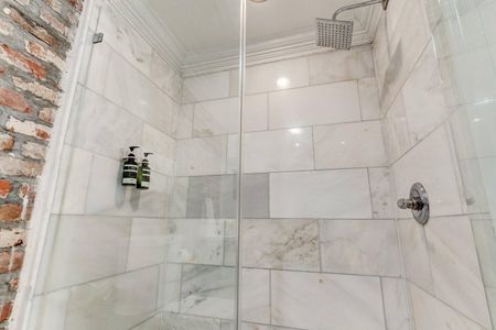 Clean, tiled shower space w/ modern finishes.