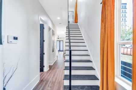 Grand entryway w/ striking black & wood staircase leading up to the bedrooms.