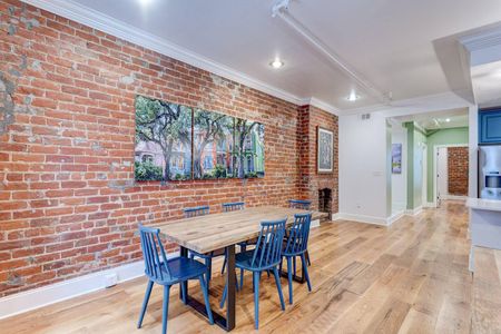 Dining space w/ seating for six, surrounded by warm exposed brick.