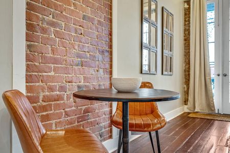 Intimate coffee lounge dining area w/ exposed brick & a cozy round table.