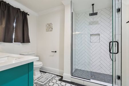 Fresh bathroom w/ herringbone tile accent wall & modern fixtures.