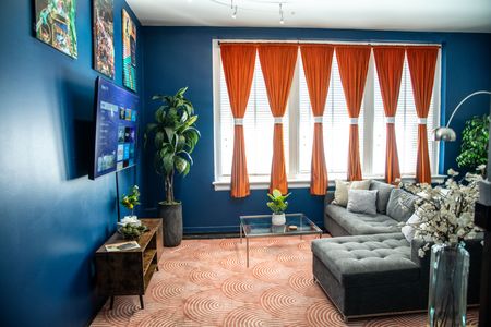 Bold blues, warm light & flowing curtains — a living space full of character & energy.