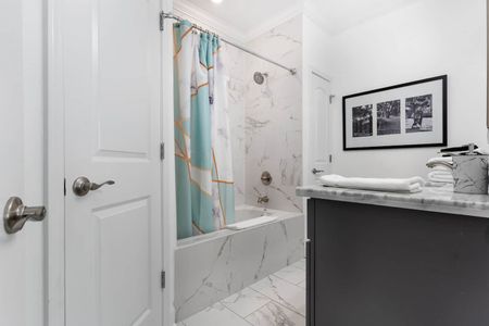 Warm wood vanity adds a charming touch to this bathroom.