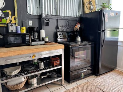 Compact kitchen w/ essentials & a wooden counter for easy meal prep.