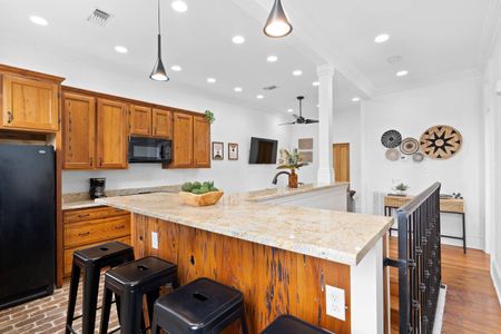 Spacious kitchen w/ a large island & warm wood cabinetry perfect for cooking together.