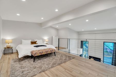 Spacious and airy, this upstairs bedroom features large windows, recessed lighting, and cozy vibes—perfect for unwinding above it all.