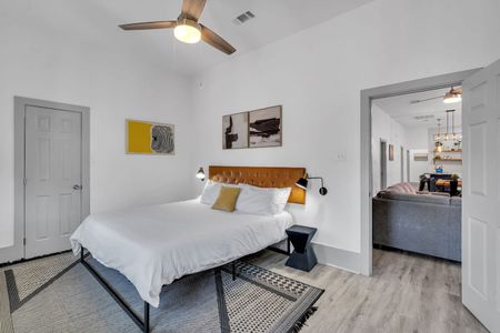 Sunlit bedroom w/ a plush bed, warm bedside lamp, & clean modern finishes.