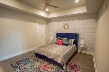 Restful bedroom w/ blue upholstered bed & warm, layered bedding.