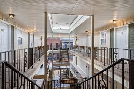 Sunlit walkway balcony w/ open railings and breezy feel.