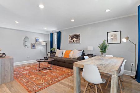 Airy living & dining space w/ natural light & stylish pops of color.