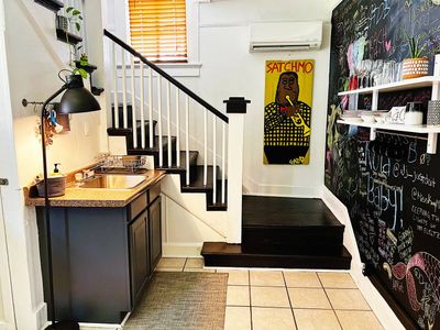 Kitchen sink area w/ a staircase leading up to the bedrooms & bathroom.