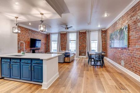 Open living & dining area w/ exposed brick — perfect for gathering w/ family.