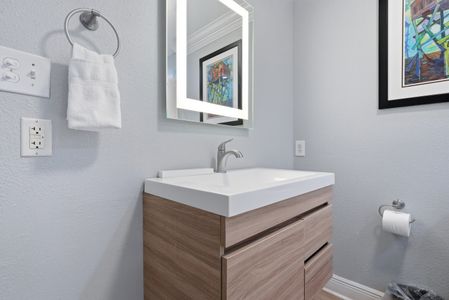 Modern vanity w/ vessel sink and clean, polished finishes.