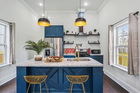 Newly renovated kitchen w/ bold blue cabinets, open shelving & pendant lights.