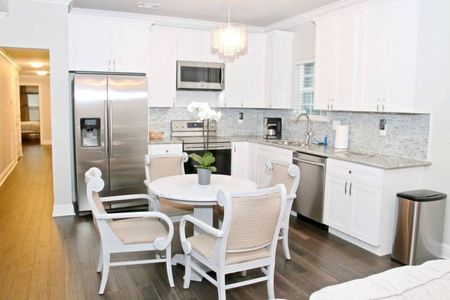 Cook & gather in the fully stocked kitchen w/ a sunlit dining area.