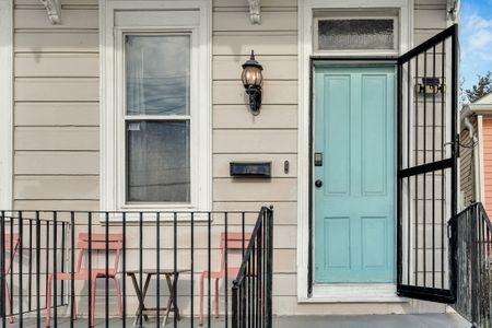 Charming teal front door w/ classic ironwork — full of local character.
