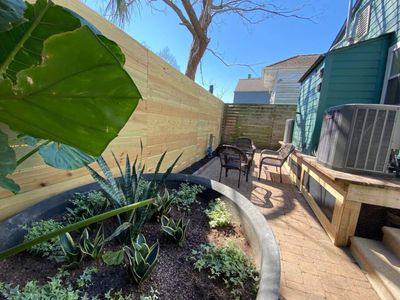 Lush front yard w/ mature plants & a welcoming, colorful exterior.