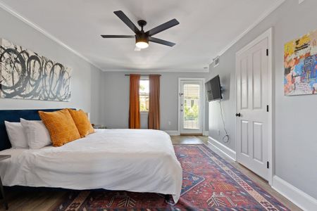 Cozy bedroom w/ ceiling fan & warm decor for a relaxing stay.