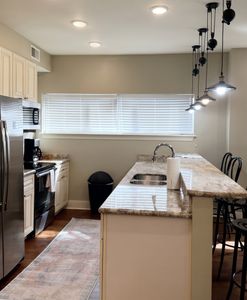Kitchen w/ granite counters & double sink, open to the living space