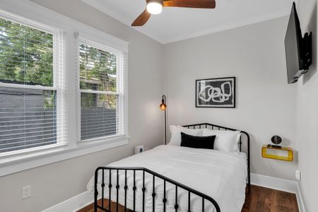 Wake up to soft daylight in this bedroom w/ an iron bed, crisp linens & modern art