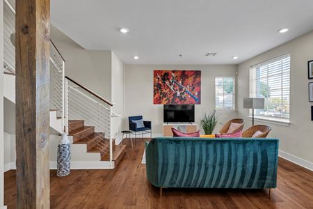 Teal sofa, red art, and a striking staircase