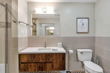 Framed art and a sleek mirror for a polished bath