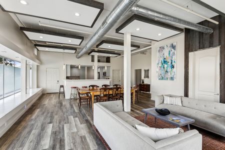 Open living & dining space w/ exposed beams & abstract art accent.